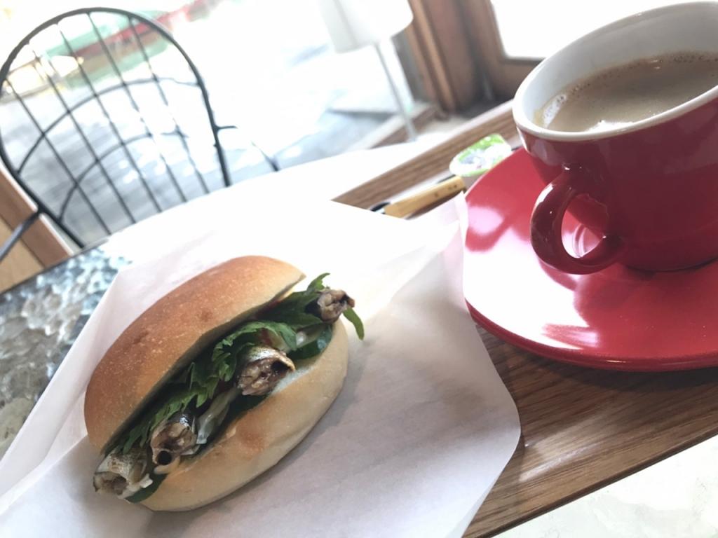 A cup of coffee and a sardine sandwich